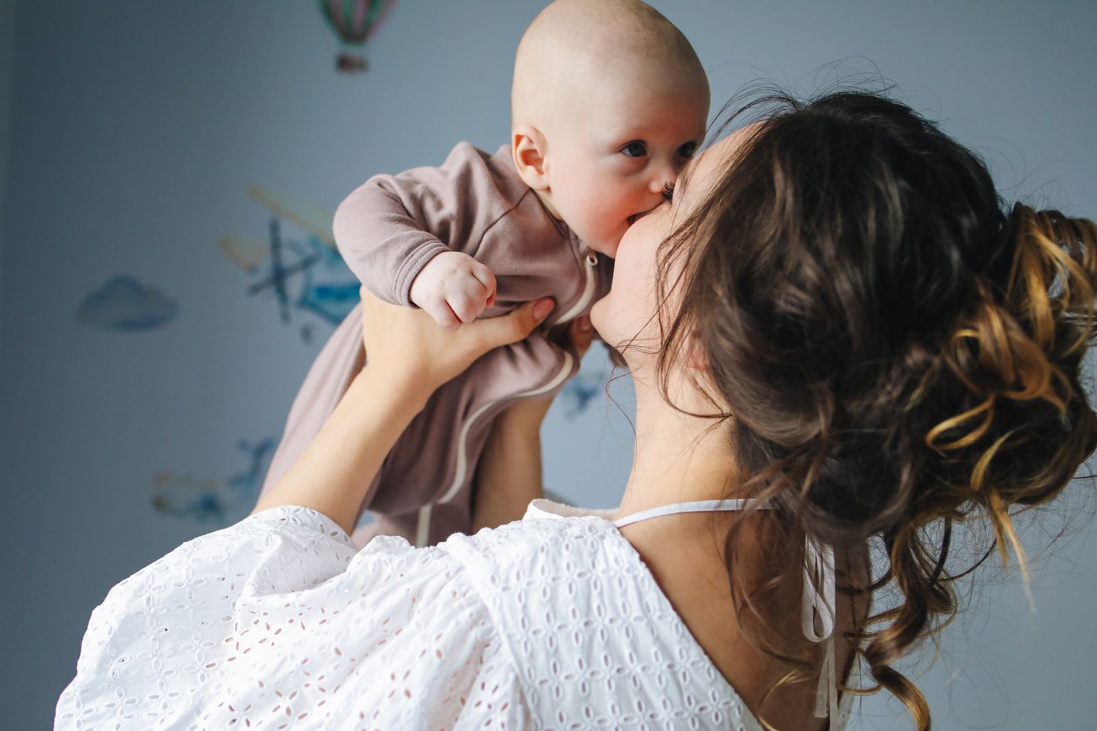 Mother kissing her baby at home
